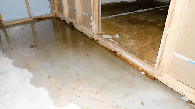 Flooded basement with standing water and open wall framing